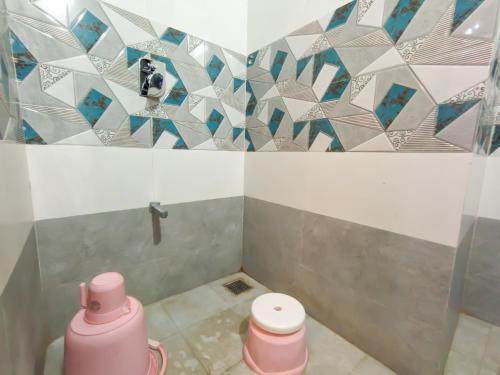 een badkamer met een douche en roze toiletten. bij Nirmal Luxury Rooms in Garudeshwar