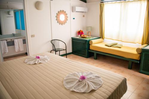 a hotel room with two beds and a bathroom at VOI Vila do Farol Resort in Santa Maria
