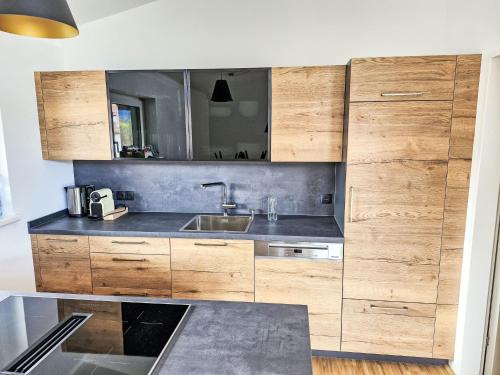 a kitchen with wooden cabinets and a sink at Apartment be home by Interhome in Mieming