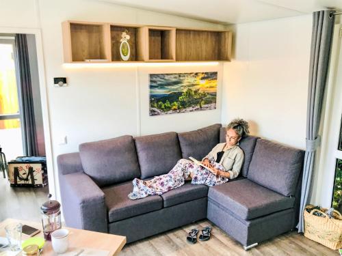 uma mulher sentada num sofá numa sala de estar em Holiday Home Tiny Haus Andreas by Interhome em Beilngries