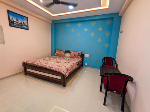 a bedroom with a bed and a chair in it at Nirmal Luxury Rooms in Garudeshwar