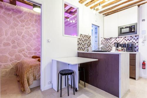 - une cuisine avec un comptoir et une table dans une pièce dans l'établissement At Place Bastille near Metro and Maris Modern Comfort in the Heart of Parisian History, à Paris