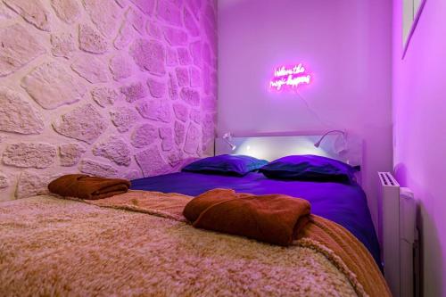 - une chambre dotée d'un lit avec une lumière violette dans l'établissement At Place Bastille near Metro and Maris Modern Comfort in the Heart of Parisian History, à Paris