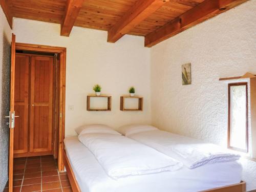 a large bed in a room with a window at Holiday Home Rustico Montanara by Interhome in Leontica