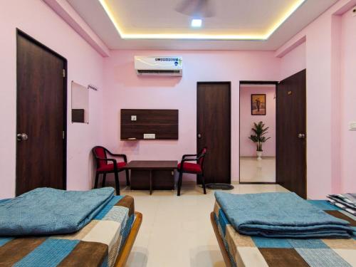 a hospital room with two beds and a table at Nirmal Luxury Rooms in Garudeshwar