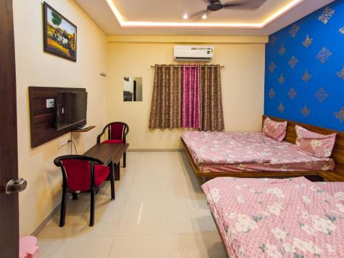 a room with two beds and a table and chairs at Nirmal Luxury Rooms in Garudeshwar