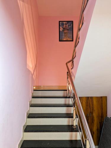 a staircase in a house with orange walls at Nirmal Luxury Rooms in Garudeshwar