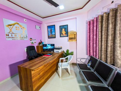an office with pink walls and a desk and chairs at Nirmal Luxury Rooms in Garudeshwar
