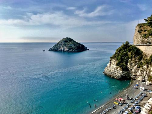a beach with a small island in the water at Bali Loft Savona Albissola in Savona
