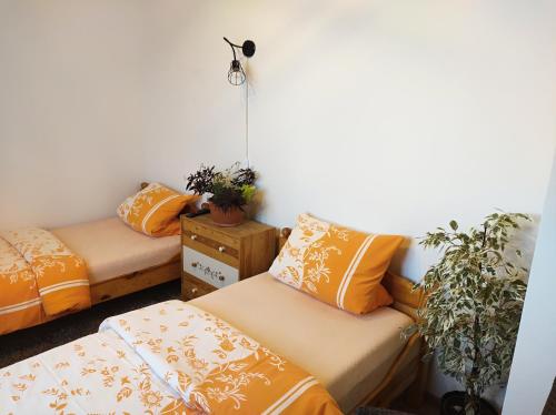 JahodnáにあるChalupy Majer Biffarのオレンジ色の枕が備わる客室内のベッド2台