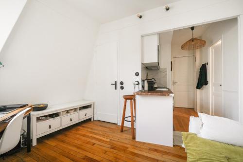 une cuisine blanche avec un comptoir et une table dans l'établissement Luxe appartement Parisien, à Paris