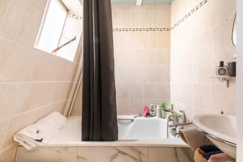 une salle de bain avec une baignoire et un lavabo dans l'établissement Luxe appartement Parisien, à Paris
