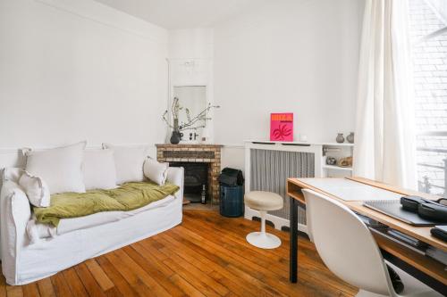 - un salon avec un canapé blanc et un bureau dans l'établissement Luxe appartement Parisien, à Paris