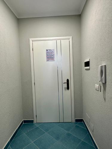 a hallway with a door in a room with blue tiles at Eri Apartments 2 in Shëngjin