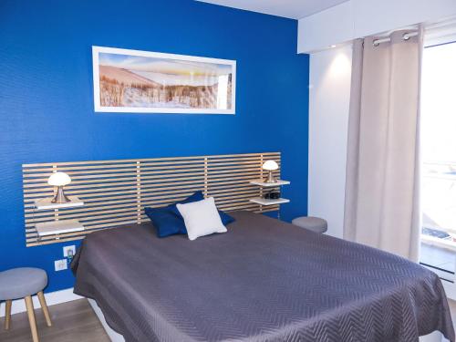 - une chambre bleue avec un grand lit aux murs bleus dans l'établissement Apartment L'Hippocampe T2 balcon et large vue mer by Interhome, à Les Sables-dʼOlonne
