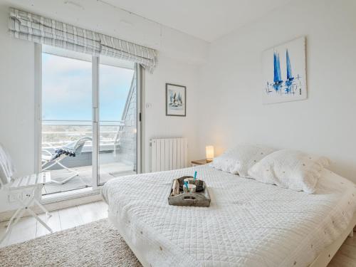 - une chambre blanche avec un grand lit et une grande fenêtre dans l'établissement Apartment Le Parc de La Ronceray 7 - L'Horizon by Interhome, à Dinard