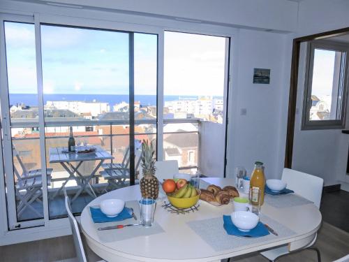 une table blanche avec un bol de fruits dessus dans l'établissement Apartment L'Hippocampe T2 balcon et large vue mer by Interhome, à Les Sables-dʼOlonne