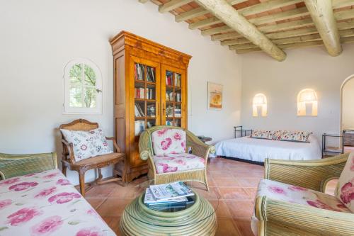 a bedroom with a bed and chairs in a room at Orangerie in Bonnieux