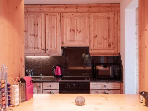 a kitchen with wooden cabinets and a stove top oven at Apartment Jade 22 by Interhome in Villars-sur-Ollon