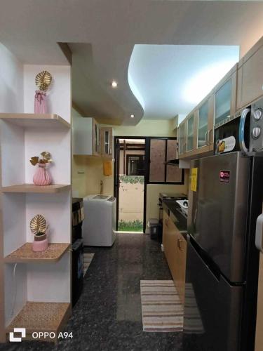 a kitchen with a stainless steel refrigerator and cabinets at One Oasis Davao Condo 2BR Behind SM Mall with WIFI & Pool in Davao City