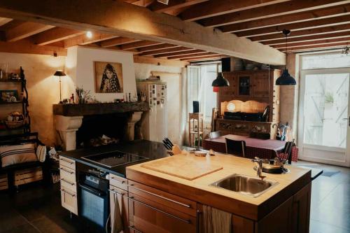 une cuisine avec un évier et une cuisinière dans l'établissement Maison paisible et chaleureuse ds la nature 12 personnes, à Faleyras