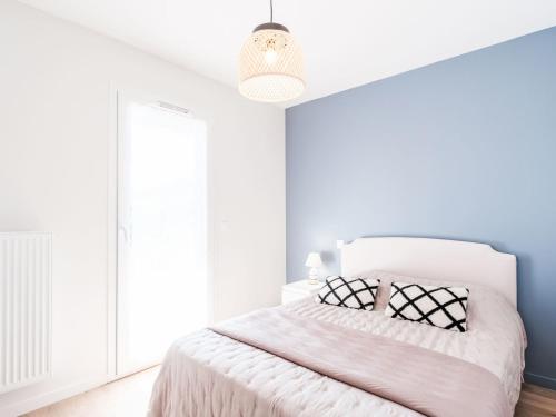 - une chambre blanche avec un lit et une lampe pendant dans l'établissement Apartment Le Patio Mauresque by Interhome, à Arcachon