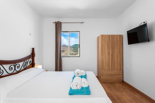 1 dormitorio con 1 cama con 2 toallas en sunset lodge, en Las Manchas