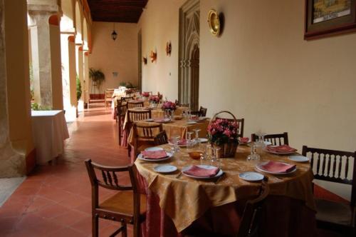 a dining room with long tables and chairs with flowers at Hospederia del Real Monasterio in Guadalupe