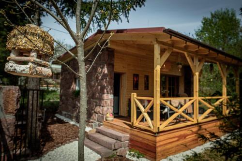 a log cabin with a porch and a fence at Love Shack in Balatonudvari
