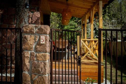 a gate to a porch with a stone pillar at Love Shack in Balatonudvari