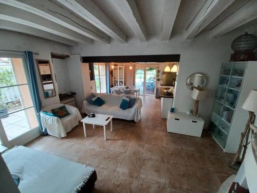 ein Wohnzimmer mit einem Sofa und einem Tisch in der Unterkunft Maison climatisée en campagne, terrasses couvertes grand jardin ombragé et piscine in Aix-en-Provence