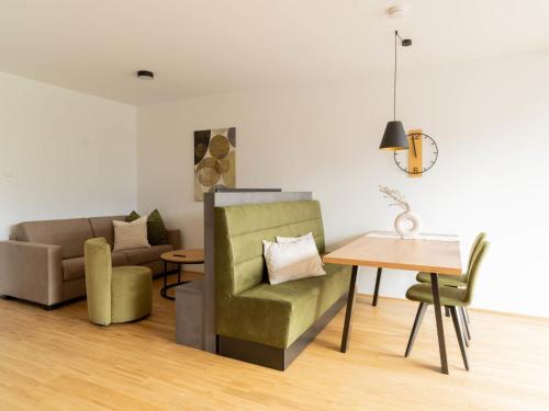 a living room with a green chair and a table at Apartment be calm by Interhome in Mieming