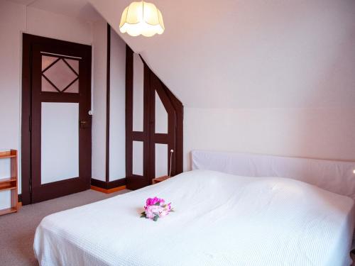 a bedroom with a white bed with a flower on it at Apartment Plan Névé 5 by Interhome in Villars-sur-Ollon