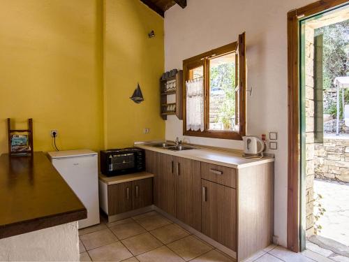 een kleine keuken met een wastafel en een raam bij Adamantia Traditional Village in Bogdanátika