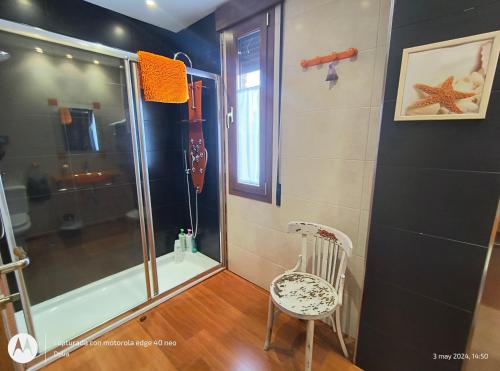y baño con ducha con puerta de cristal y silla. en Casa Rural Casa Jacinta, en San Cristóbal de Segovia