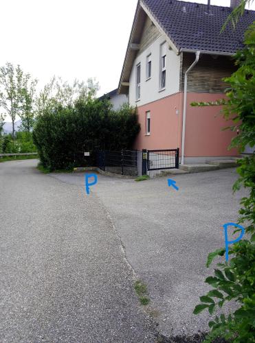 a driveway with blue arrows in front of a house at FeApp Souterrain Pennen & Parken in Mondsee