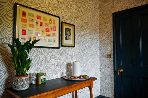 a room with a table with a plant on a wall at The Dover Stop in Dover