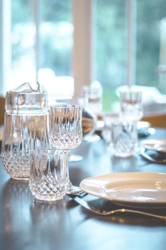 a table with glasses and a plate on it at VILLA LES PEUPLIERS in Royan