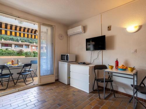 une petite cuisine avec une table et un micro-ondes dans l'établissement Studio Les Aigues Marines-70 by Interhome, à Saint-Cyr-sur-Mer