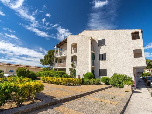 un bâtiment blanc avec des buissons devant dans l'établissement Studio Les Aigues Marines-70 by Interhome, à Saint-Cyr-sur-Mer
