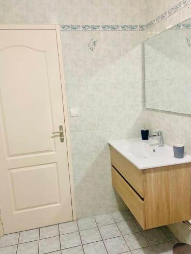 La salle de bains est pourvue d'un lavabo, d'un miroir et d'une porte. dans l'établissement Maison 1 , possibilité 2 eme maison mitoyenne,Le Crotoy, proche mer - Baie de Somme, au Crotoy