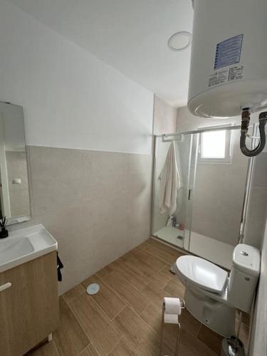 a bathroom with a white toilet and a sink at Rockside Residences Suites La Linea in La Línea de la Concepción