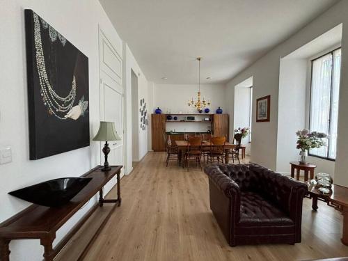 Casa 9 Esquinas - Granada في غواذالاخارا: غرفة معيشة مع أريكة وغرفة طعام
