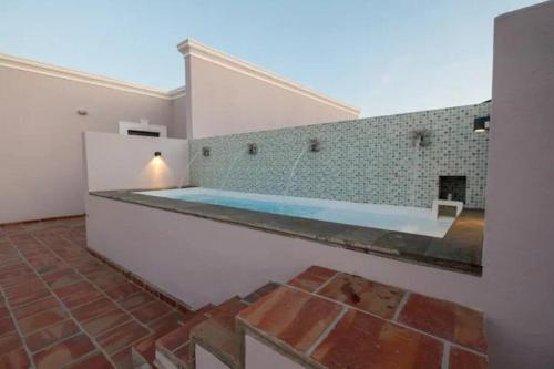 a large swimming pool in a room with a brick floor at Casa 9 Esquinas - Granada in Guadalajara