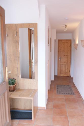 a hallway with a mirror and a wooden door at Ferienwohnung beim Binder in Grabenstätt