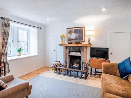 a living room with a fireplace and a tv at Holiday Home Dancot by Interhome in Invermoriston