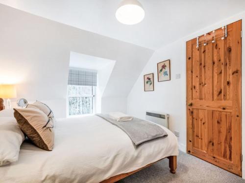 a bedroom with a bed and a wooden door at Holiday Home Dancot by Interhome in Invermoriston