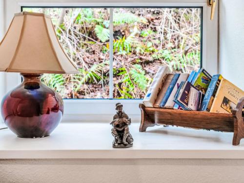 a table with a lamp and books on a window sill at Holiday Home Dancot by Interhome in Invermoriston