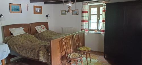 Kemenesmihályfa的住宿－Letűnt Idők Vendégház，一间卧室配有一张床和两张凳子