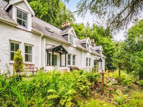 an old white house in the middle of a garden at Holiday Home Dancot by Interhome in Invermoriston